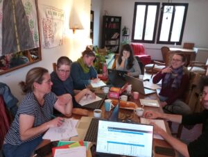 De nombreuses personnes travaillent autour d'une table sur leurs ordinateurs et discutent
