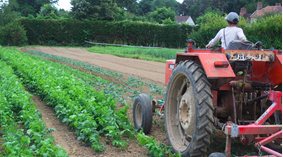 Une femme conduit un tracteur dans un champ
