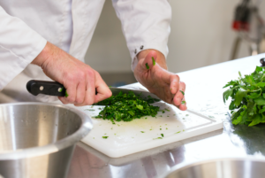 Une personne découpe des fines herbes en cuisine