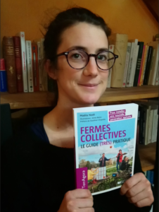 Une femme pose avec son livre à l'occasion de sa parution