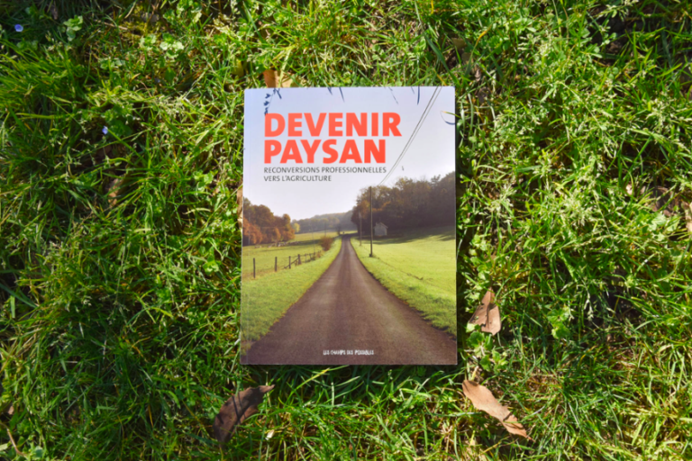 Vue de la couverture du livre Devenir paysan, déposé dans l'herbe.