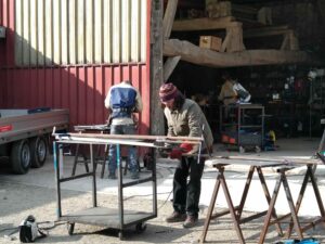 Une personne travaille une planche de bois dans un hangar