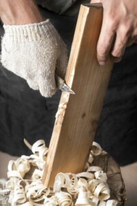 Gros plan sur une personne qui travaille une planche de bois